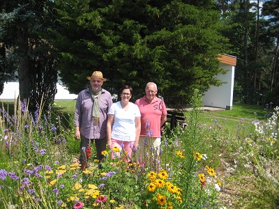 Menschen stehen neben einem blühenden Garten
