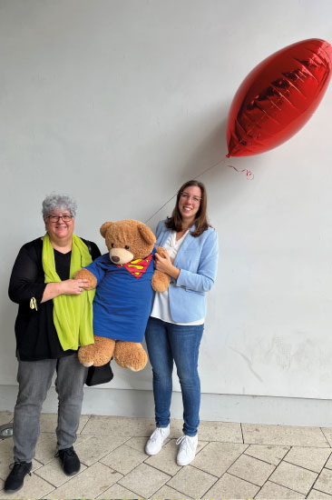 Personalchefin Cornelia Dietrich und Franziska Schott mit Teddy und Herz-Luftballon
