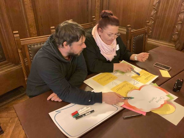 Zwei Menschen sammeln Ideen für die digitale Verwaltung.