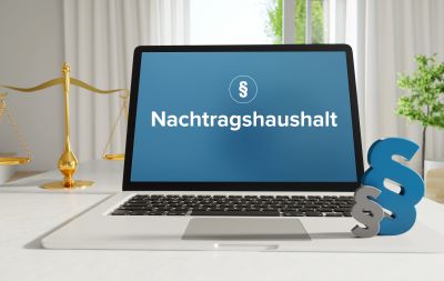 Nachtragshaushalt Symbolbild laptop mit Paragraf und Schrift Nachtragshaushalt