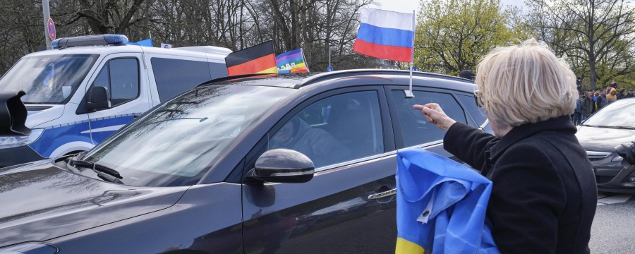 Prorussischer Autokorso mit Russlandfahne und Gegendemonstrantin mit Ukraine-Fahne