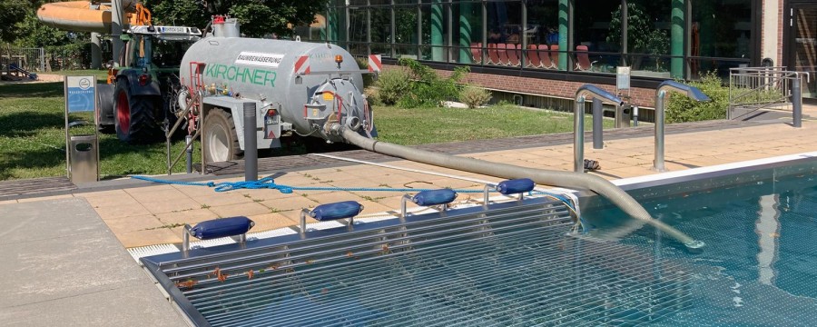 Ein Wässerwagen pumpt Wasser aus dem Außenbecken des Südstadtbads