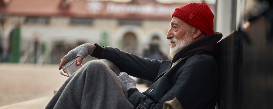 Obdachloser Mann sitz auf der Straße