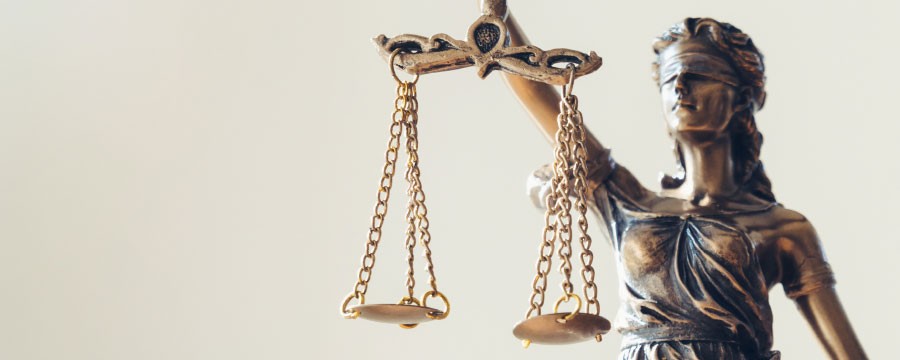 Justitia mit zwei Waagschalen als Symbol für Gerechtigkeit und Rechtspflege