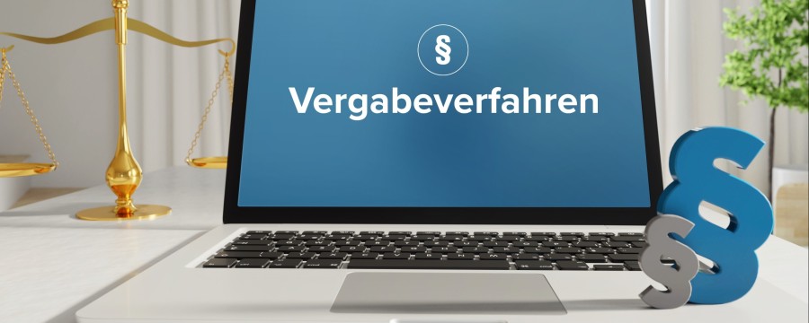 Laptop mit Aufschrift Vergabeverfahren und einem Paragrafen-Zeichen