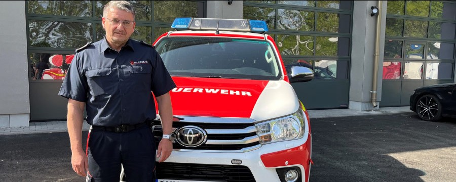 Oberhavels Kreisbrandmeister Gerd Ritter vor dem Feuerwehrauto am TAZ