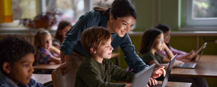Kinder und Lehrerin Laptops