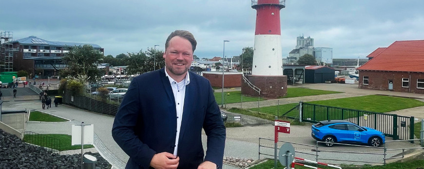 Büsums Bürgermeister Oliver Kumbartzky vor dem Leuchtturm am Hafen.