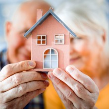 Senioren-Paar betrachtet ein Modellhaus