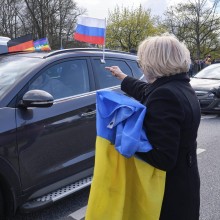 Pro-russischer Autokorso mit Russlandfahne und Gegendemonstrantin mit Ukraine-Fahne
