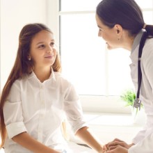 Ärztin mit Mädchen im Gespräch bei der Untersuchung