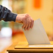 Wahlurne: Wahlzettel wird eingeworfen