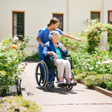 Altenheim: Ältere Dame mit Pflegerin im Garten