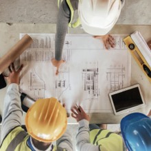 Bauturbo Menschen beugen sich über Pläne