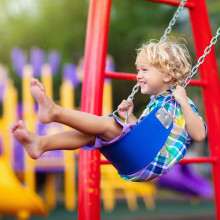 Spielplatzsicherheit: Kind auf Schaukel